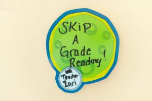 Colorful sign with 'Skip a Grade Reading' promoting educational advancement.