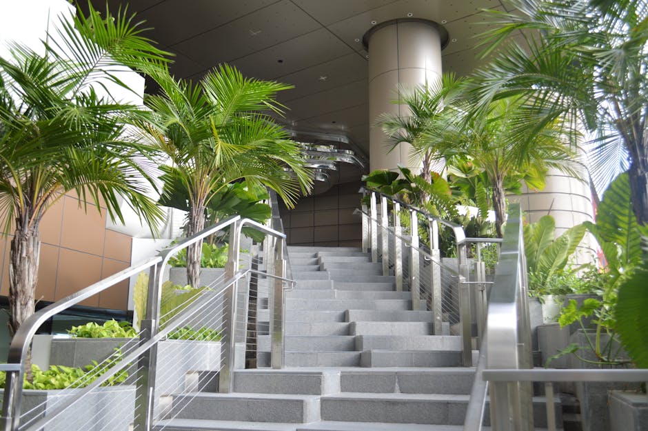 A contemporary staircase lined with lush green plants, providing a refreshing indoor environment.