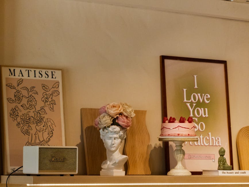Charming shelf featuring a Matisse print, flower crown bust, and strawberry cake.
