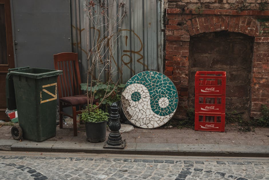 Rustic urban alley with yin-yang mosaic, Coca-Cola crates, and potted plants.