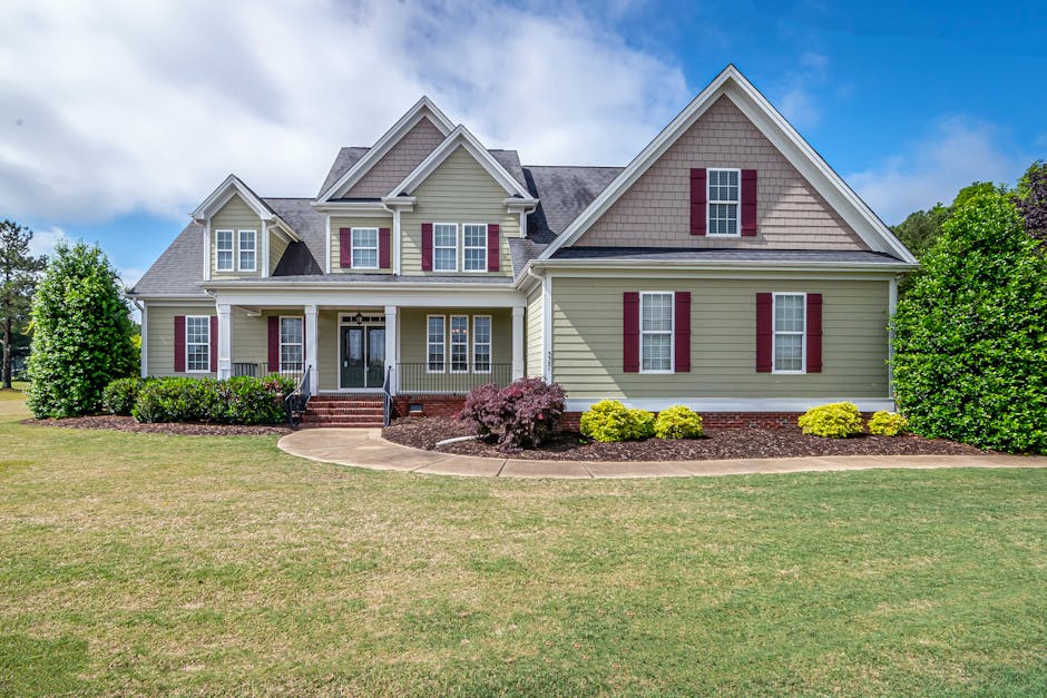 Beautiful two-story suburban house with manicured lawn and front porch.