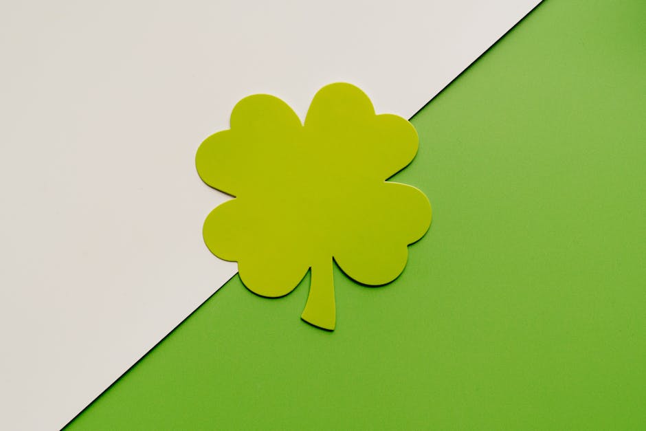 A simple, minimalist four leaf clover design on a green and white background, perfect for festive themes.