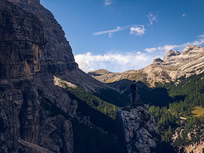 Hiker enjoying breathtaking view from a peak in the Dolomites, Cortina d’Ampezzo, Italy.